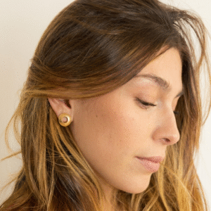 Small gold-plated bronze Glass Frog Studs inspired by Colombia’s glass frog on a natural background.