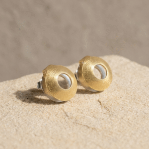 Small gold and silver Glass Frog Studs inspired by Colombia’s glass frog on a natural background.