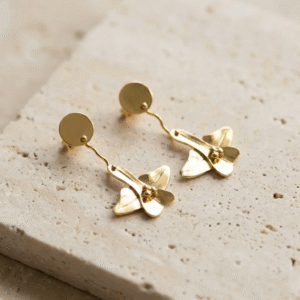 Mini Orchid Earrings in 24k gold-plated bronze with delicate floral shapes, photographed on a natural light background.